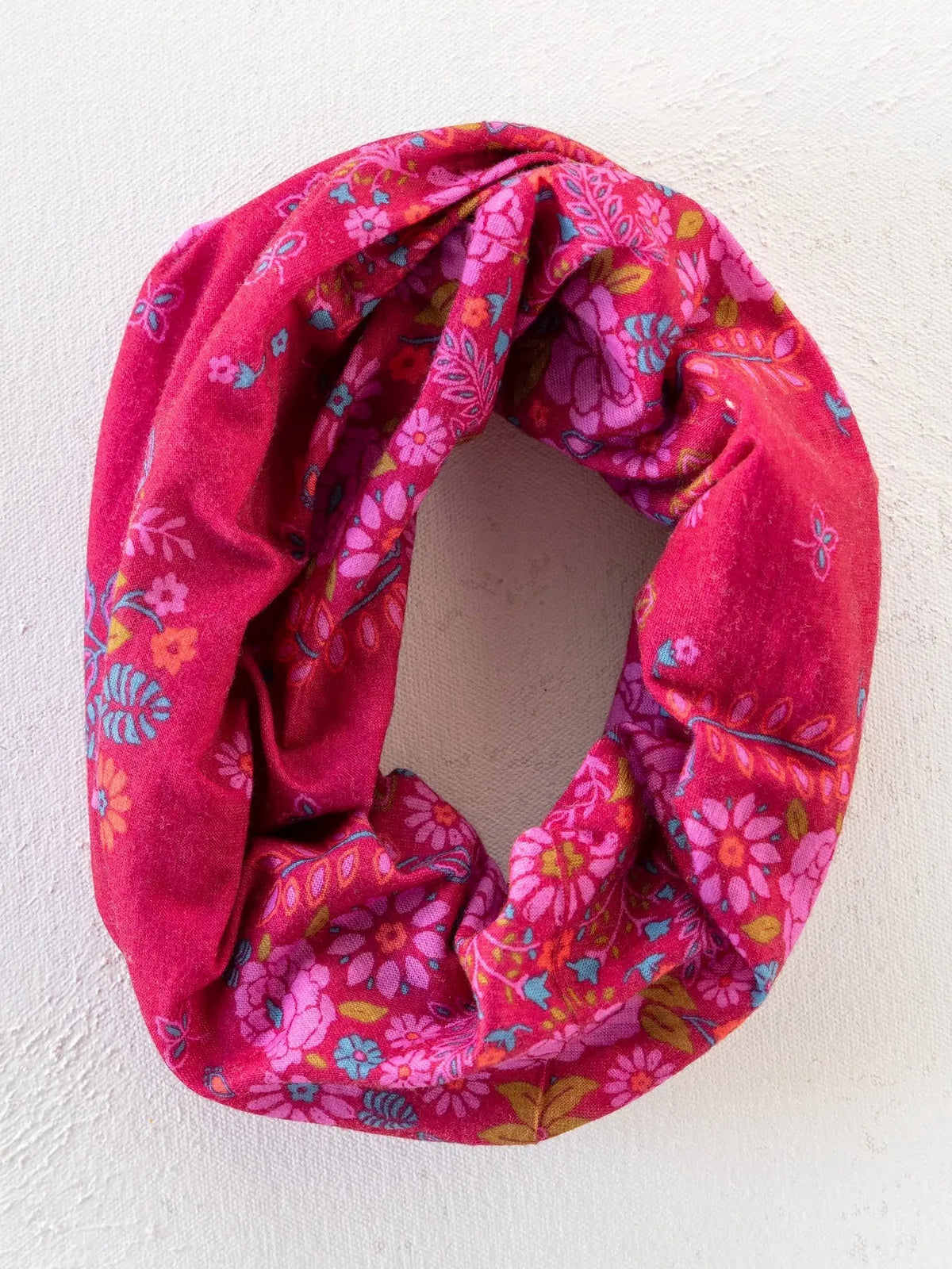A vibrant pink floral boho bandeau headband with soft textured fabric and colorful blossoms in merlot bandana style