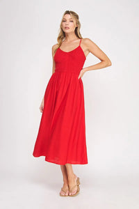 A vibrant red sleeveless bodice maxi dress with a smocked bodice and flowing midi skirt