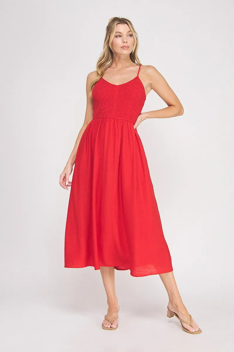 A vibrant red sleeveless midi dress featuring a smocked bodice and flowing skirt in a bodice maxi style
