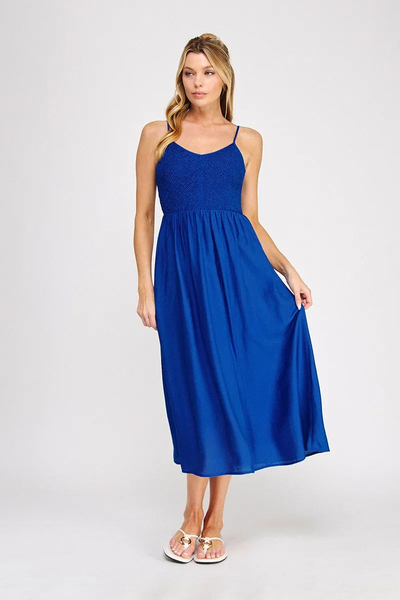 A vibrant royal blue smocked bodice maxi dress with a textured bodice and flowing satin skirt