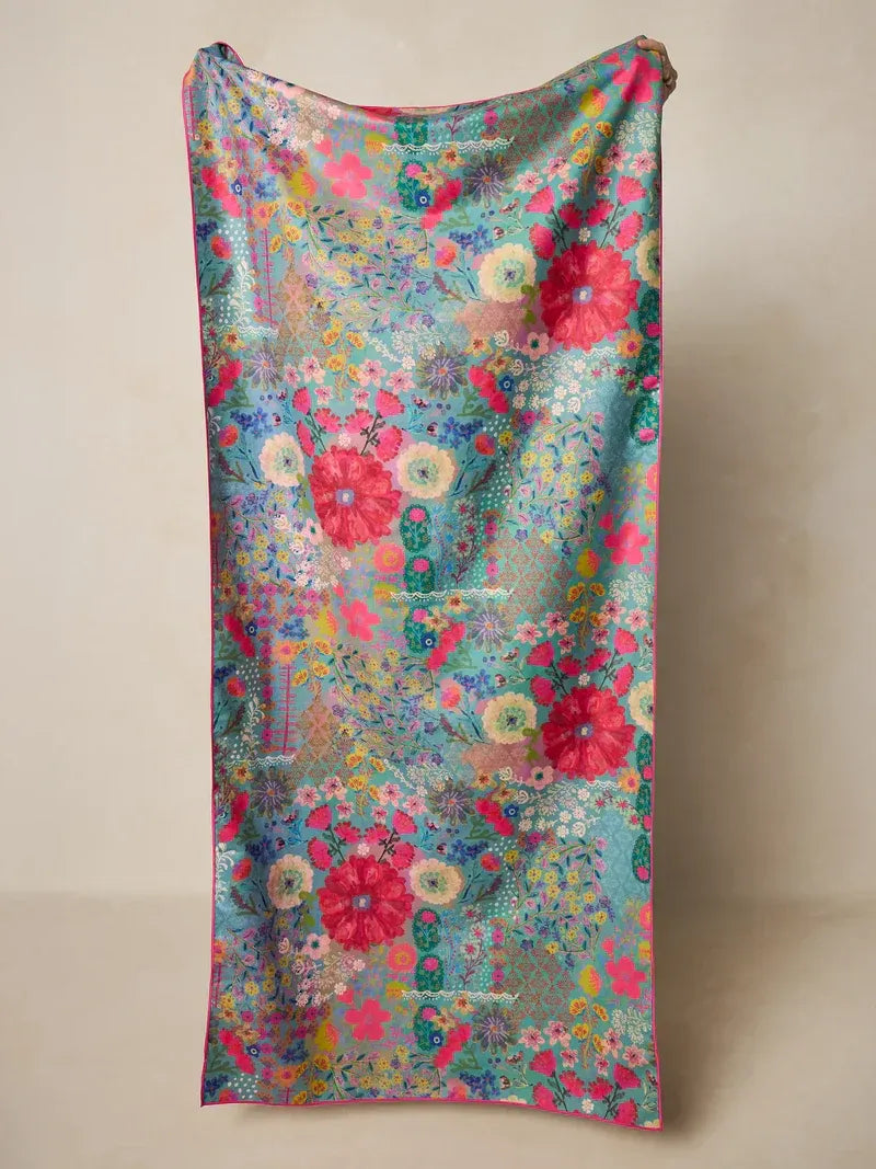 A vibrant double sided microfiber beach towel with a sheer floral pattern in pink red and teal favorite color design