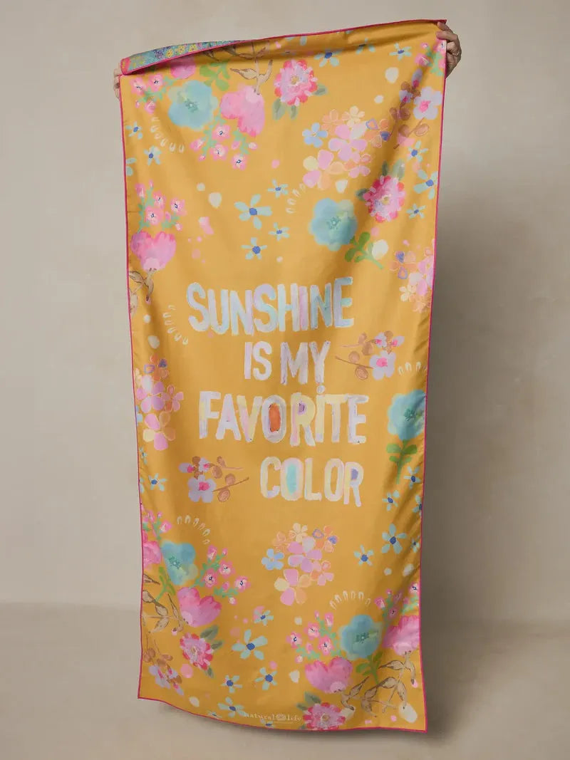 A vibrant yellow double sided microfiber beach towel with a colorful floral pattern and favorite color text