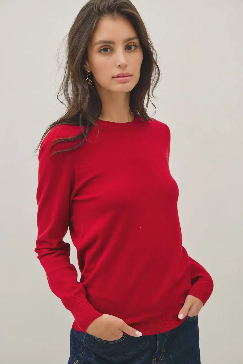 A vibrant red viscose crew neck knit sweater with long sleeves and a smooth soft knit texture