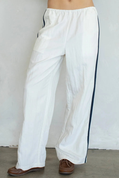 White landon track pocket double line pants with black side stripes designed for athletic use