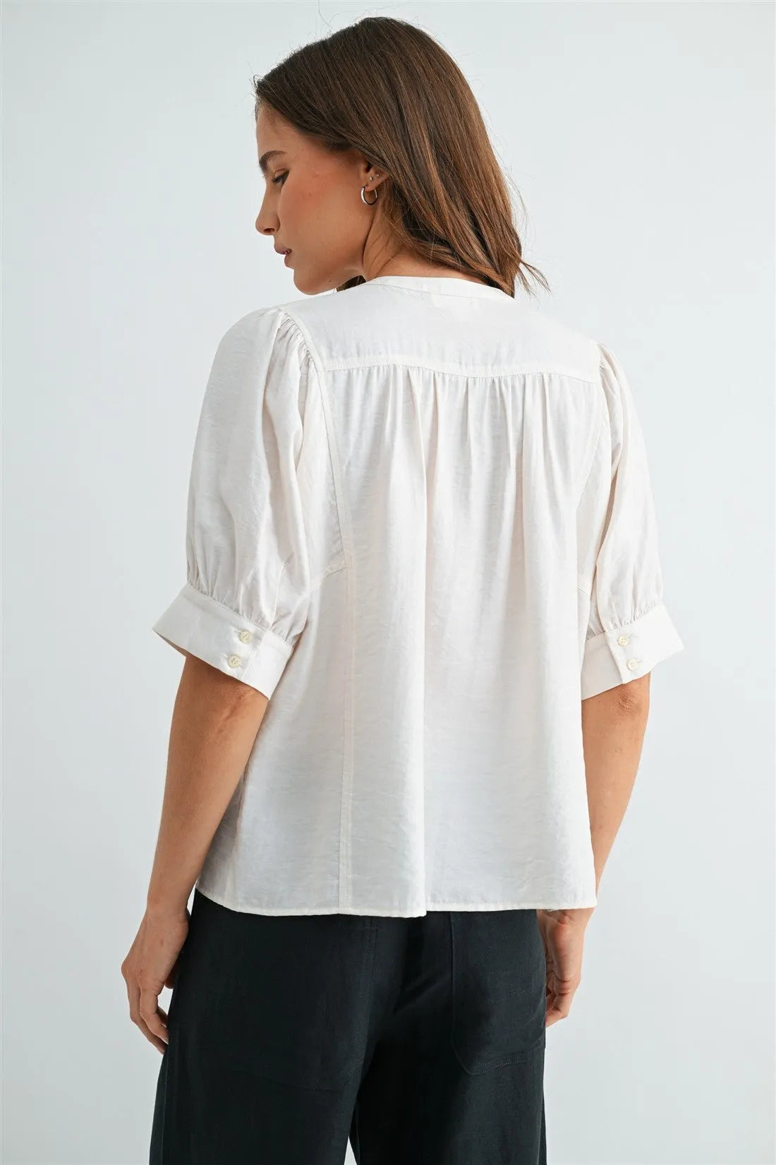 White button down short sleeve blouse with puffed sleeves and buttoned cuffs in lightweight fabric