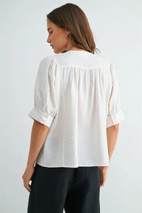 White button down short sleeve blouse with puffed sleeves and buttoned cuffs in lightweight fabric