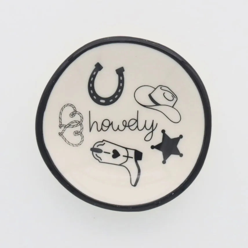 A white ceramic ring dish howdy with black rim featuring hand-drawn cowboy-themed illustrations for western decor