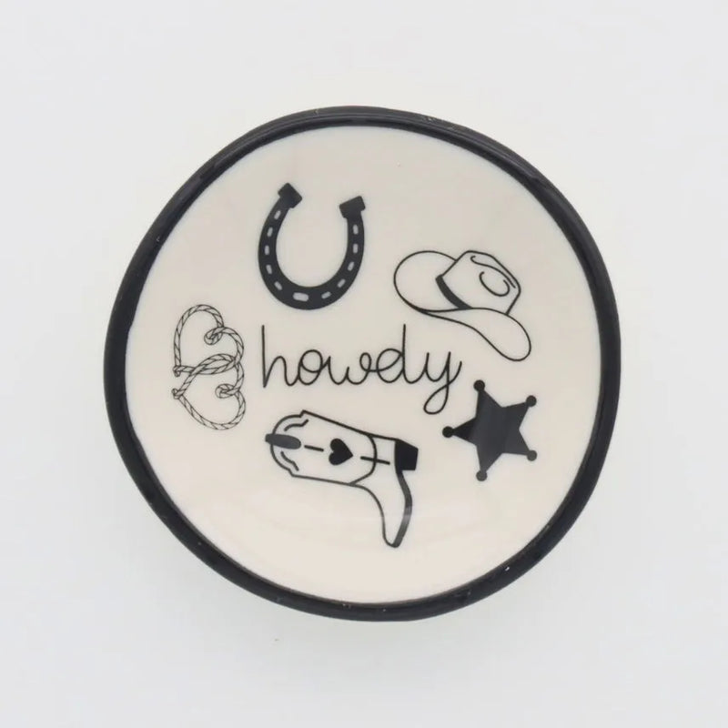 A white ceramic ring dish howdy with black rim featuring hand-drawn cowboy-themed illustrations for western decor