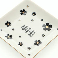 White ceramic trinket tray with black flowers and gold centers featuring you make the world a better place lettering