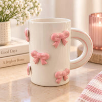 Stoneware mug in white ceramic featuring a pink 3d bow design perfect for enjoying favorite hot beverages