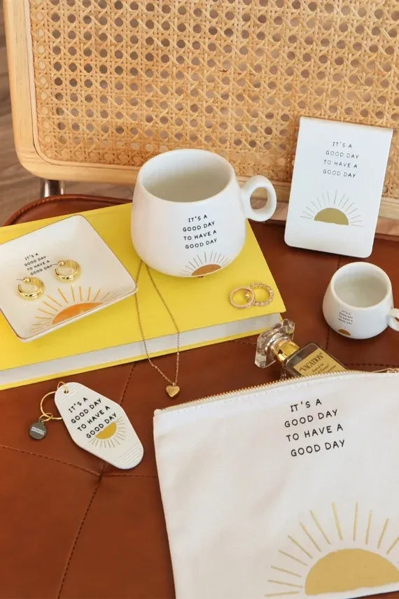 White ceramic mug with black text and gold sun design featuring a gold rim for a good day trinket tray use