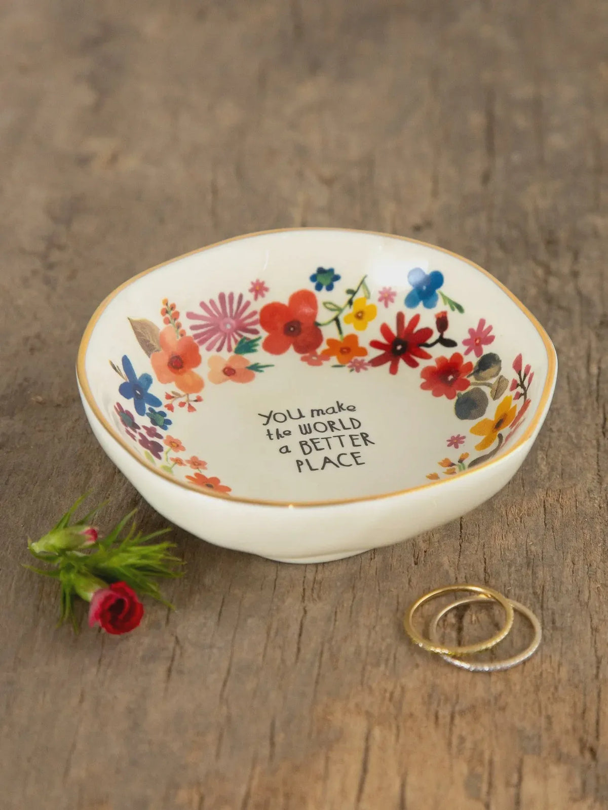 A white ceramic trinket bowl with colorful floral pattern and you make the world a better place inscription perfect for shop daisy users