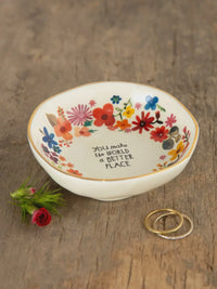 A white ceramic trinket bowl with colorful floral pattern and you make the world a better place inscription perfect for shop daisy users