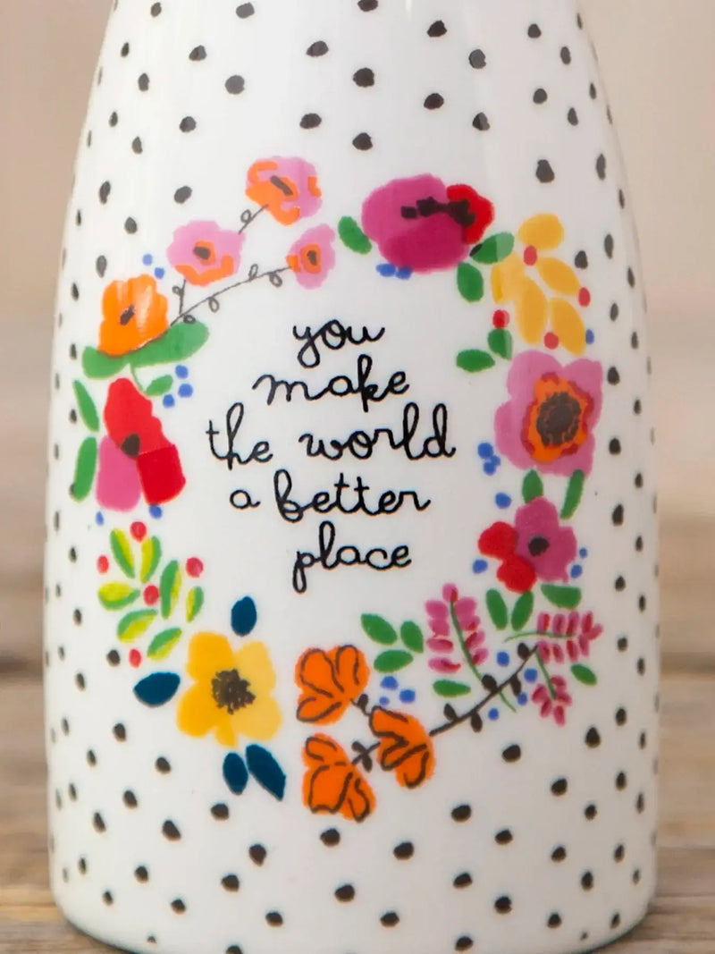 White ceramic bud vase with black polka dots and floral wreath featuring you make the world a better place design