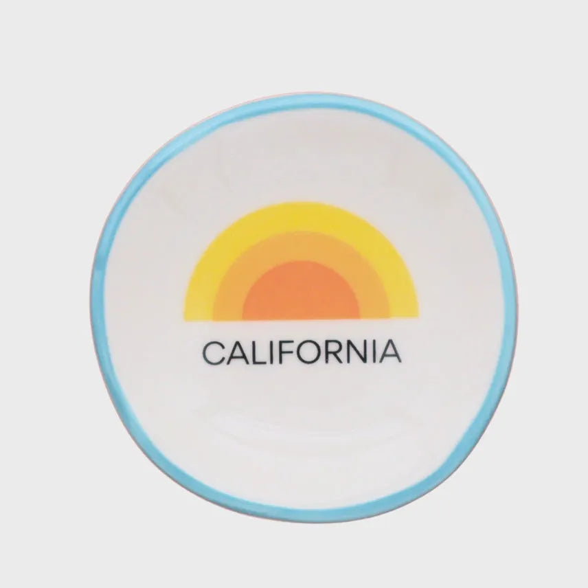 A white ceramic ring dish california with a light blue rim featuring a colorful rainbow and the word California
