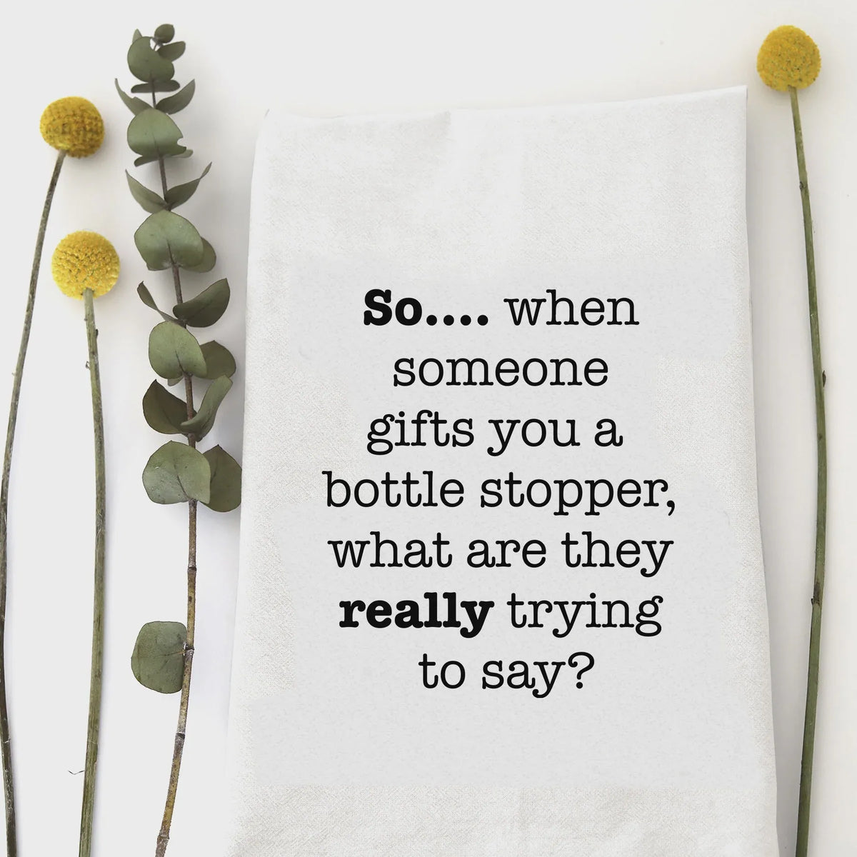 White cotton bottle stopper tea towel with black printed text so for kitchen use