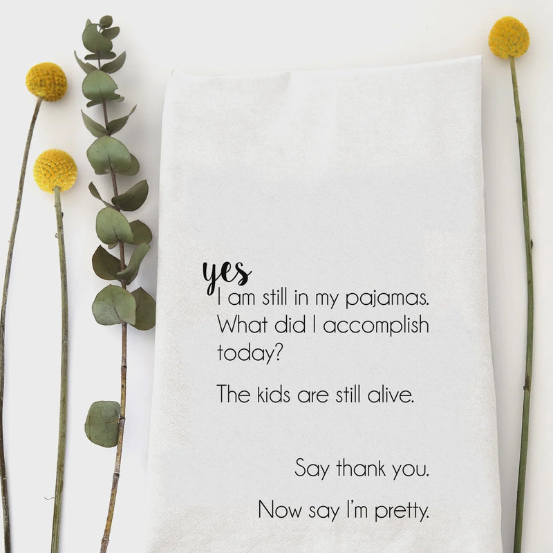 White cotton pajamas tea towel with black text: yes i am still in my pajamas