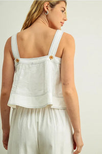 White denim stitch detailed sleeveless top with thin straps and gold-tone buttons at shoulder seams