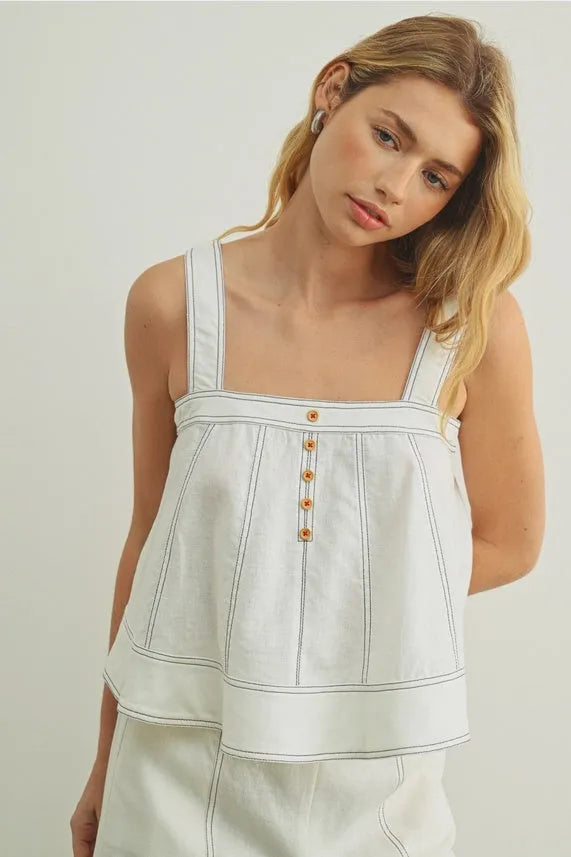 White denim stitch detailed sleeveless top with thin straps and subtle vertical stitching for casual wear