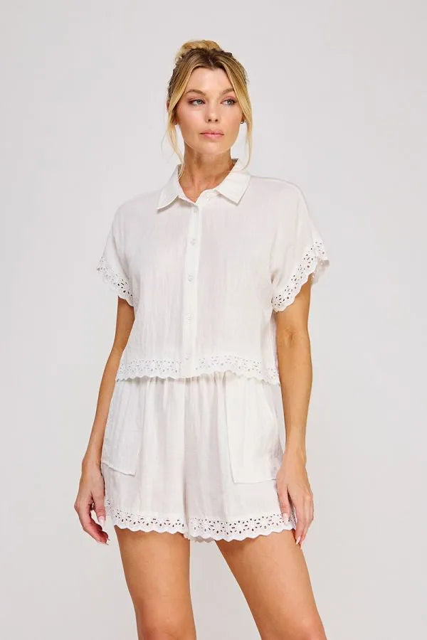 White eyelet cotton romper with short sleeves and button front showcasing a linen blend short sleeve design
