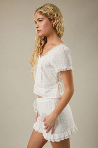White eyelet crochet cap sleeve scoop neck blouse with lace trim and ruffled hem in short sleeves design