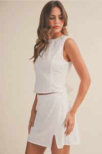 White eyelet sleeveless top with high neckline on slit mini skort