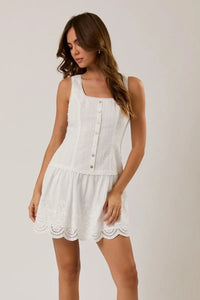 White sleeveless eyelet mini dress with button-front bodice and scalloped hem in eyelet lace fabric
