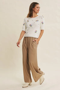 White floral embroidered short-sleeve knit top paired with step washed wide leg pants for a casual look