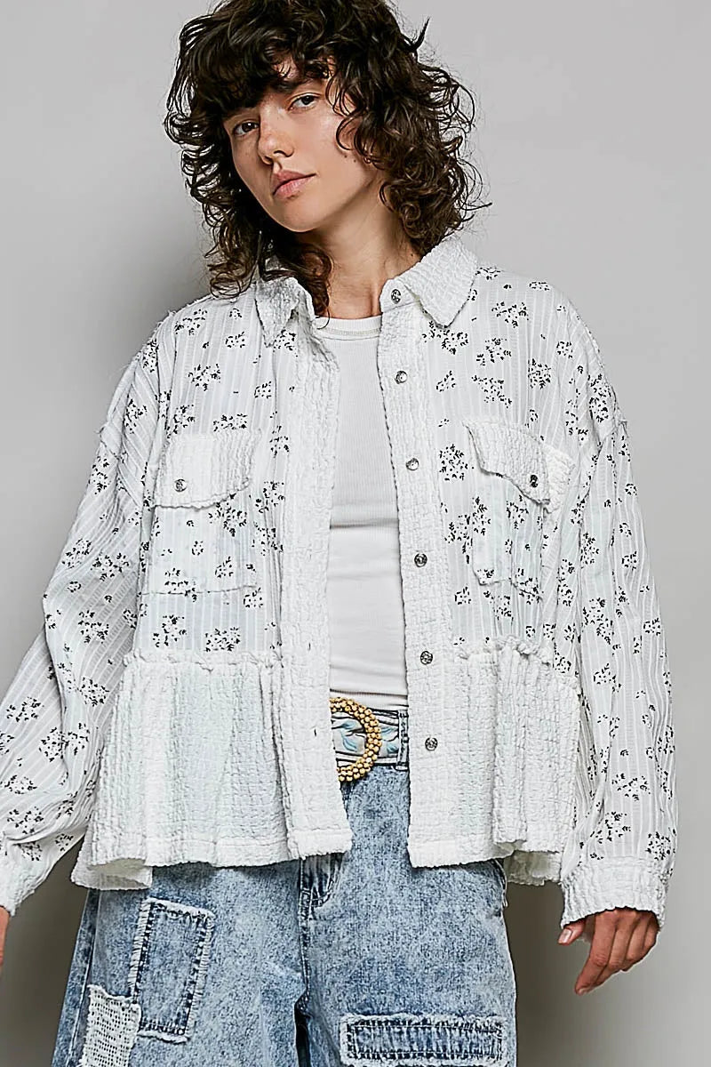 White cotton shirt jacket with floral ruffle detailing button closures and ruffled hem front pockets