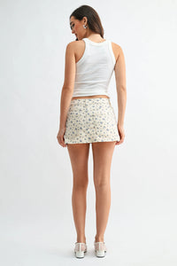 Classic mini denim high rise skort in white floral-patterned denim with five-pocket design and button closure