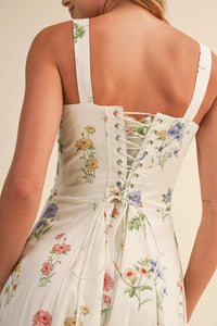 Back view of a white floral tie midi dress with corset style lace up detail in women’s boho chic clothing style