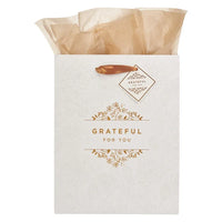 White gift bag with gold foil lettering floral design and gold ribbon handle grateful for you tag shop daisy gift bag