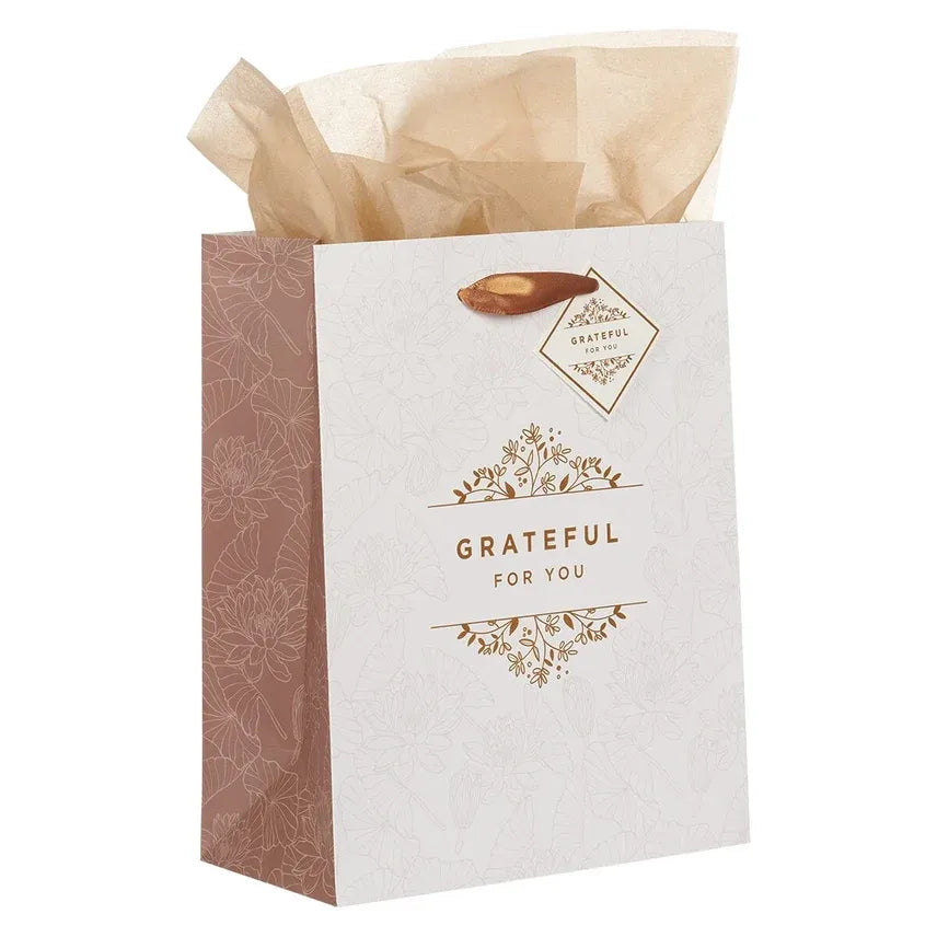 A white gift bag with brown floral pattern and gold foil grateful for you lettering for shop daisy women’s boho chic clothing