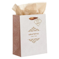 A white gift bag with brown floral pattern and gold foil grateful for you lettering for shop daisy women’s boho chic clothing