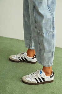 White and gray adidas samba sneakers with black stripes and brown soles paired with checker board pattern barrel denim pants