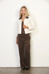 White jacket with black collar paired with brown satin pants featuring garment faded wash canvas barn design