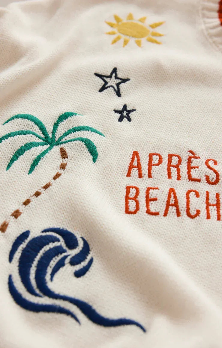 White knit sienna sweater with embroidered tropical design and orange après beach text from the day sienna collection