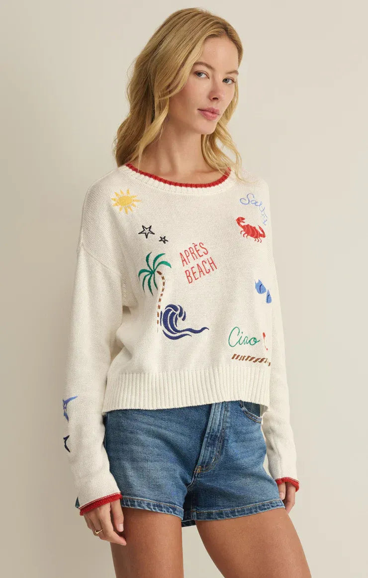 White knit day sienna sweater with colorful embroidered beach designs and red trim on neckline and cuffs