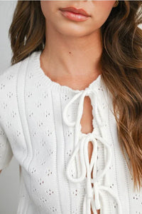 White scalloped tie front pointelle knit top with lace-up detail featuring textured pattern for women’s boho chic clothing