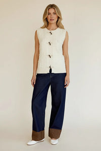 Cable knit sleeveless cardigan vest: white with black toggles, frayed hem