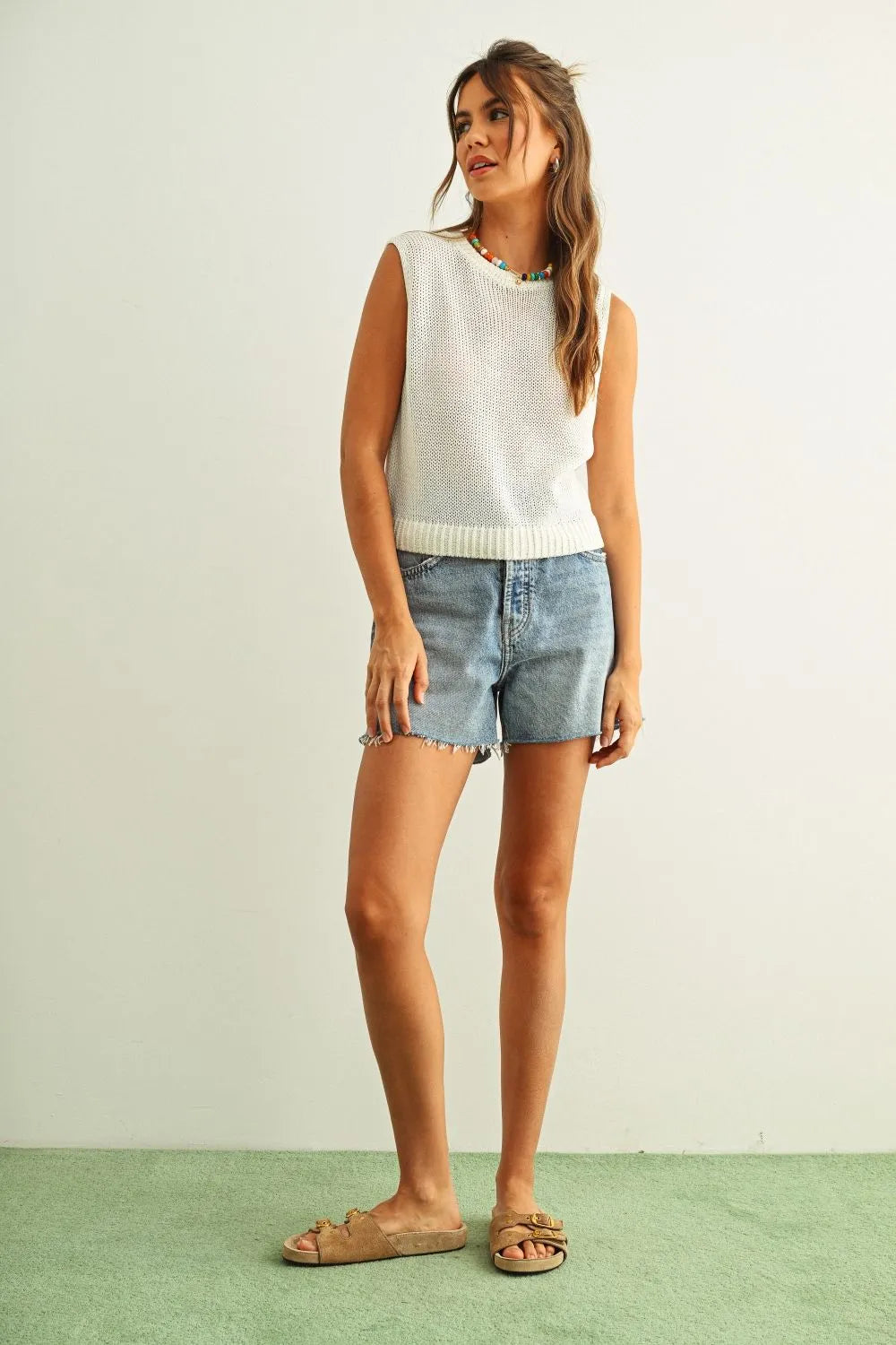 White sleeveless round neck knitted top with ribbed hem and neckline made from soft knit fabric