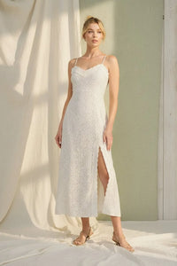 White lace maxi dress with delicate spaghetti straps, high slit, scalloped lace trim, and polka dot accents