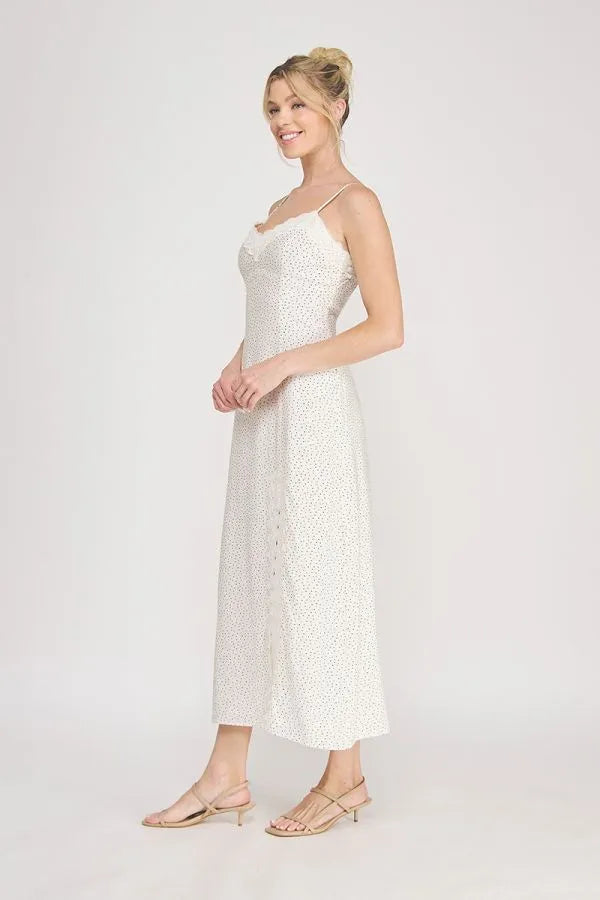 White lace midi slip dress with scalloped lace trim polka dot detailing and delicate spaghetti straps with slit