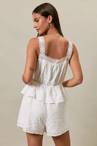 White lace-trimmed peplum romper with square neck lace trim detail and ruffled tiers in a relaxed fit