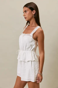 White lace-trimmed sleeveless romper with tiered peplum waist and drawstring detail