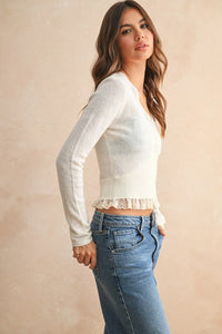 White long-sleeved knit crop top with delicate lace trim at hem in lace contrasted knitted cardigan style