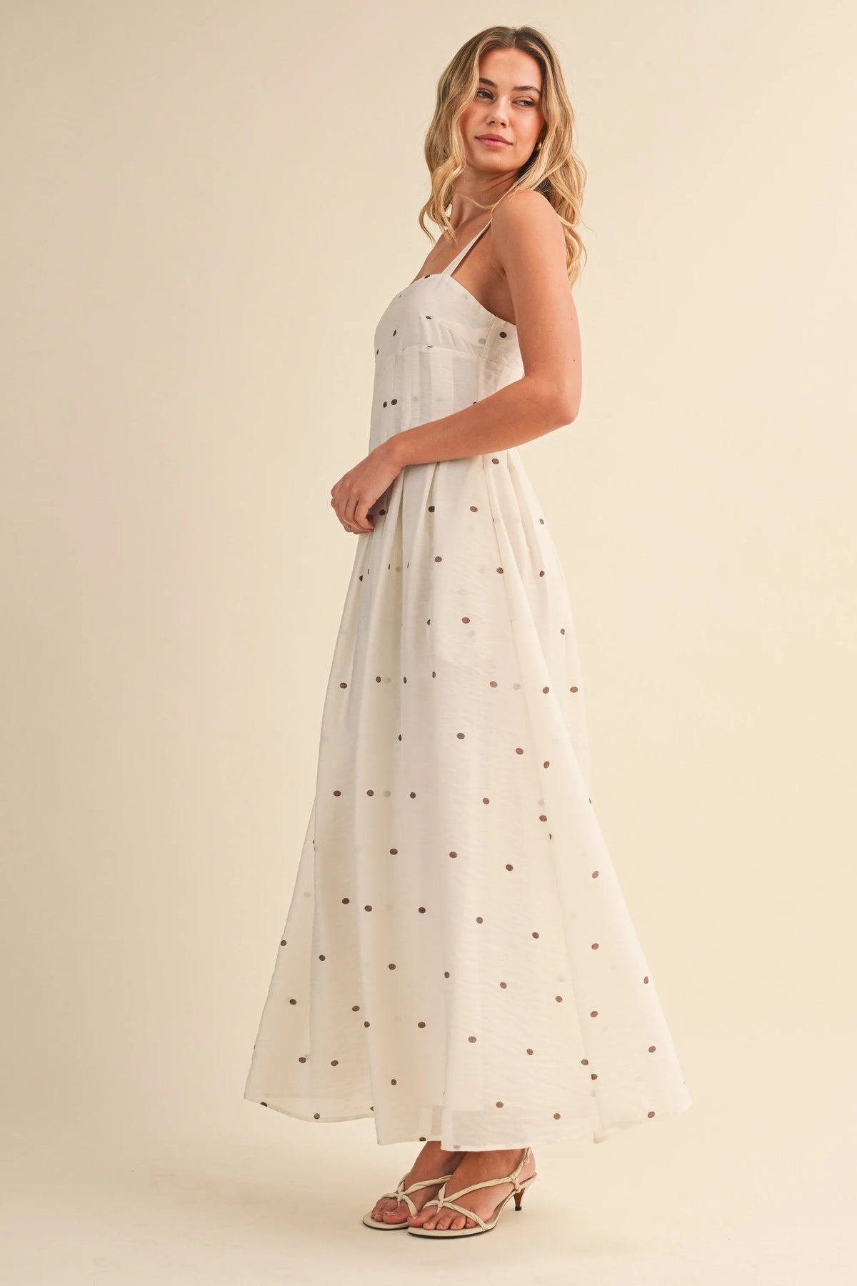 A flowing white maxi dress with delicate black polka dot pin tuck detailing and thin spaghetti straps