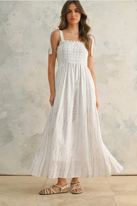 Flowing white women’s maxi dress with tie dye print and smocked neckline