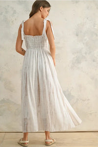 Flowing white women’s maxi dress with tie-back straps and smocked bodice