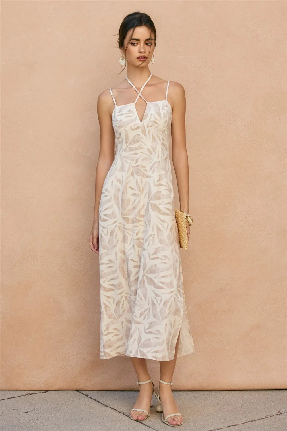 A flowing white tropical leaf v cut sleeveless maxi dress with a subtle leaf pattern and delicate straps
